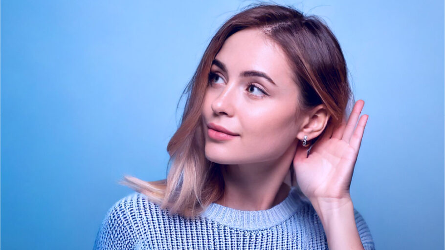 Kobieta nasłuchująca dźwięków – symbol analizy hałasu pompy ciepła i komfortu akustycznego